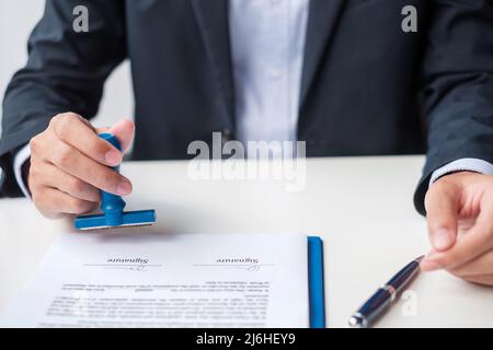 Cachet de l'homme d'affaires au moment de la signature du contrat. Contrat d'affaires, approbation, partenariat, contrat et concepts d'assurance qualité Banque D'Images