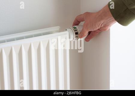 Tournez manuellement le bouton de réglage du thermostat sur la soupape du radiateur pour économiser de l'énergie en raison du prix du chauffage. Contrôle de la température. Banque D'Images