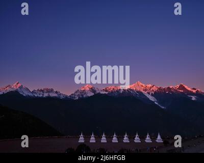 pagodes blanches du temple feilai avec la montagne de neige de meili au lever du soleil en arrière-plan dans la province chinoise du yunnan Banque D'Images