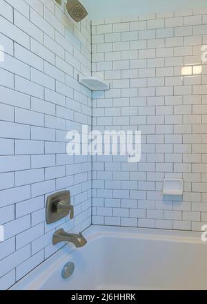 Baignoire alcôve verticale avec carrelage de métro blanc et coulis noir Banque D'Images