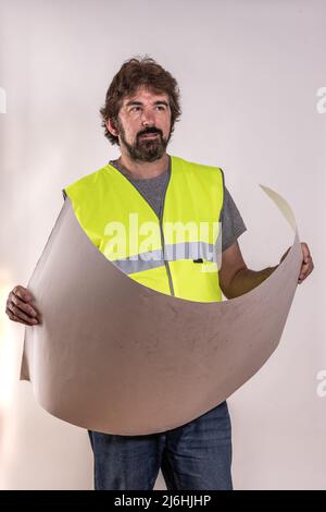 Architecte chargé de la supervision de la construction, portant une veste réfléchissante et tenant un plan. Homme barbu d'âge moyen. Arrière-plan blanc Banque D'Images