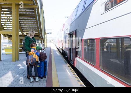 Famille d'immigrants ukrainiens avec bagages à la gare, concept de guerre ukrainien. Banque D'Images