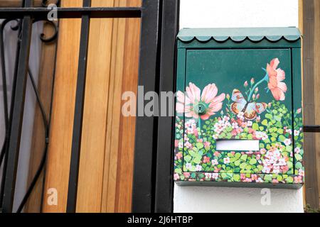 Finestrat, Alicante, Espagne - 23 avril 2022 : boîte aux lettres en métal vert peinte avec des motifs floraux à la porte Banque D'Images