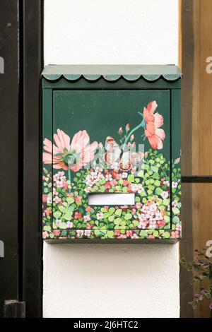 Finestrat, Alicante, Espagne - 23 avril 2022 : boîte aux lettres en métal vert peinte avec des motifs floraux à la porte Banque D'Images