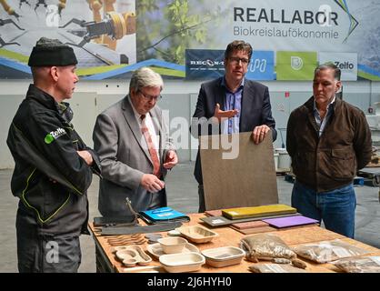 02 mai 2022, Brandebourg, Schwedt : Edoardo Gordillo (r), fondateur de Bio-lutions Deutschland GmbH, et Richard Hurding (l), PDG de Zelfo Technology, expliquent les produits de leurs sociétés à Jörg Steinbach (2nd de gauche, SPD), ministre de l'économie et du travail de Brandebourg, Et Michael Kellner (Bündnis 90/Die Grünen), secrétaire d'État parlementaire au ministère fédéral de l'économie et de la protection du climat, au début de la tournée de bioéconomie. Le Ministère fédéral allemand de l'économie et de la protection du climat (BMWK) a compilé un atlas de régions échantillons pour la bioéconomie industrielle, qui sera Banque D'Images