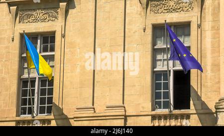 Le drapeau de l'Ukraine et le drapeau européen à la fenêtre agitant dans le vent. À l'appui de l'invasion de l'Ukraine et de son adhésion à l'Union européenne Banque D'Images