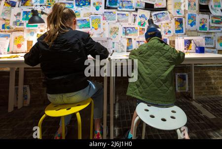 London Shoreditch, Royaume-Uni. 30 avril 2022. Parent avec enfants à colorier un imprimé à l'exposition Van Gogh The Immersive Experience. Banque D'Images