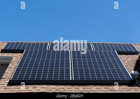 Un panneau solaire résidentiel monté sur un toit en bardeaux en asphalte avec espace de copie Banque D'Images