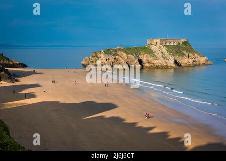 Tenby South Beach, vue sur une soirée d'été de personnes marchant sur South Beach avec l'île Sainte-Catherine à proximité, Tenby, Pembrokeshire, pays de Galles Banque D'Images