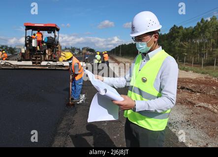 (220502) -- NAIROBI, le 2 mai 2022 (Xinhua) -- Yuan Wanfu examine un dessin technique sur un chantier de construction à Nairobi, Kenya, le 23 avril 2022. Yuan Wanfu, 31 ans, travaille au sein de la succursale de China Road & Bridge Corporation au Kenya depuis septembre 2015 et est désormais responsable du projet d'expansion de East Ring Road à Nairobi. Yuan travaille chaque après-midi avec ses collègues chinois et kenyans sur le chantier pour identifier et résoudre les difficultés du processus de construction le plus rapidement possible. Yuan est également impliqué dans une variété de programmes de bien-être social en plus de toujours Banque D'Images