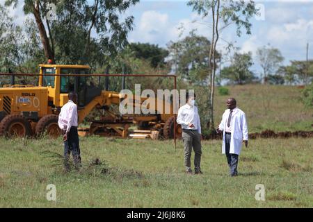 (220502) -- NAIROBI, le 2 mai 2022 (Xinhua) -- Yuan Wanfu discute d'un plan de construction avec un directeur de l'école secondaire Kamiti près d'un chantier de construction à Nairobi, Kenya, le 27 avril 2022. Yuan Wanfu, 31 ans, travaille au sein de la succursale de China Road & Bridge Corporation au Kenya depuis septembre 2015 et est désormais responsable du projet d'expansion de East Ring Road à Nairobi. Yuan travaille chaque après-midi avec ses collègues chinois et kenyans sur le chantier pour identifier et résoudre les difficultés du processus de construction le plus rapidement possible. Yuan est également impliqué dans une variété de soci Banque D'Images