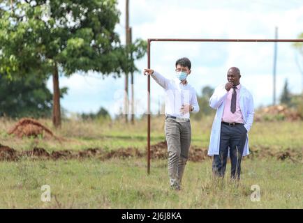 (220502) -- NAIROBI, le 2 mai 2022 (Xinhua) -- Yuan Wanfu discute d'un plan de construction avec un directeur de l'école secondaire Kamiti près d'un chantier de construction à Nairobi, Kenya, le 27 avril 2022. Yuan Wanfu, 31 ans, travaille au sein de la succursale de China Road & Bridge Corporation au Kenya depuis septembre 2015 et est désormais responsable du projet d'expansion de East Ring Road à Nairobi. Yuan travaille chaque après-midi avec ses collègues chinois et kenyans sur le chantier pour identifier et résoudre les difficultés du processus de construction le plus rapidement possible. Yuan est également impliqué dans une variété de soci Banque D'Images
