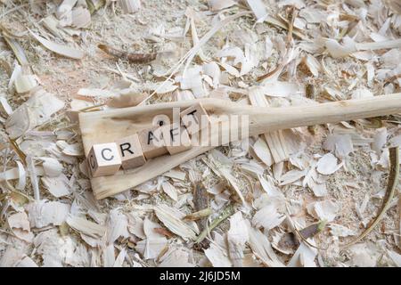 Cuillère de cuisson en bois autosculptée cuillère grattoir avec le mot - ARTISANAT - sur un établi avec des copeaux de bois, Allemagne Banque D'Images