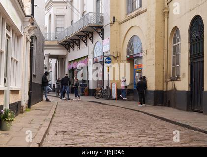 Des jeunes qui délotent dans une petite rue pavée à Boston, au Royaume-Uni Banque D'Images