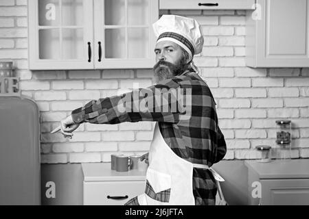 Chef cuisinier, cuisinez des plats délicieux et savoureux. Chef mâle à barbe en uniforme blanc Banque D'Images