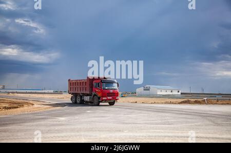 Aktau, Kazakhstan - 19 mai 2012. Développement de la zone économique libre. Red Truck FAW sur route, et bâtiment industriel de la compagnie T.E.S.C.O. Belle St Banque D'Images
