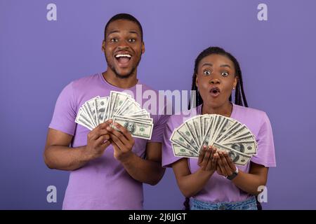 Un couple afro-américain enthousiaste qui détient beaucoup d'argent Banque D'Images