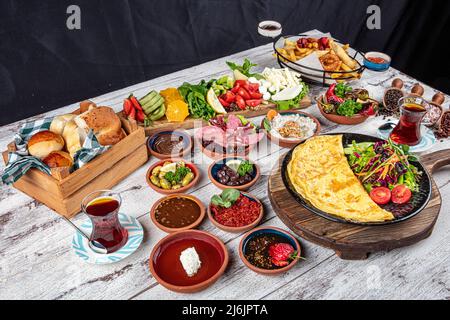 Table de petit-déjeuner turc. Pâtisseries, légumes, légumes verts, olives, fromages, omelette, épices, confitures, miel, thé dans un thermos, grande composition. Petit déjeuner Banque D'Images