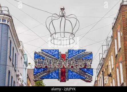 Londres, Royaume-Uni - 02 mai 2022, Une nouvelle installation a été dévoilée dans l'emblématique rue Carnaby Street célébrant le Jubilé de platine de la Reine. L'installation comprend de nouvelles enseignes avec des disques brillants et une couronne géante. La reine Elizabeth II est le premier monarque à célébrer 70 ans de service. Banque D'Images