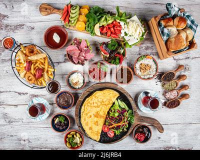 Table de petit-déjeuner turc. Pâtisseries, légumes, légumes verts, olives, fromages, omelette, épices, confitures, miel, thé dans un thermos, grande composition. Petit déjeuner Banque D'Images