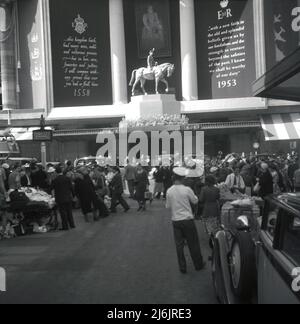 1953, historique, des foules de gens à Oxford Street, Londres, Angleterre, Royaume-Uni se rassemblent autour de l'exposition célébrant le couronnement de la reine Elizabeth II au trône. La soi-disant décoration du Couronnement de Selfridges était une statue équestre de la reine Elizabeth II sur son cheval 'Winston'. Banque D'Images