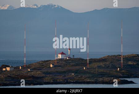 Le phare des îles Trial, un groupe d'antennes radio, et les montagnes olympiques à l'horizon. Banque D'Images