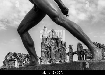 Abbaye de Whitby à travers les pattes de la statue de gladiateur Borghèse à Whitby, Yorkshire, Royaume-Uni en avril - en noir et blanc, monochrome Banque D'Images