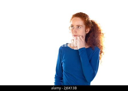 Redhaired fille pensant à quelque chose d'isolé sur un fond blanc Banque D'Images