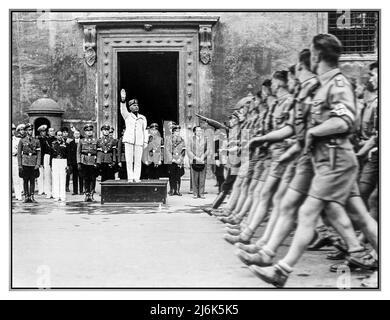 1930s Benito Mussolini lève le bras en saluant les fascistes lors d'une visite de la jeunesse nazie allemande ( Hitler Jugend) à Rome le 1 octobre 1936. Banque D'Images