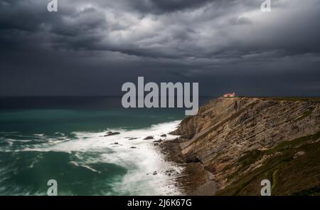 Vue sur le phare des falaises de Cabo Vidio sous un ciel couvert et orageux Banque D'Images