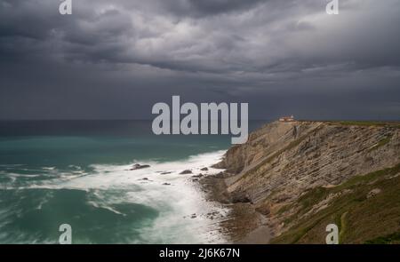 Vue sur le phare des falaises de Cabo Vidio sous un ciel couvert et orageux Banque D'Images