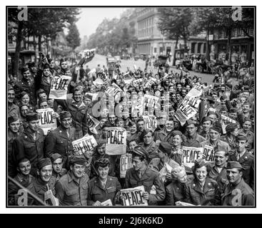 VJ DAY PARIS 1945 hommes et femmes américains se rassemblent devant le club de la Croix-Rouge "Rainbow Corner" à Paris pour célébrer la reddition inconditionnelle des Japonais. Titre "PAIX" dans le journal militaire américain "Stars and Stripes" détenu par des militaires américains extatiques en uniforme. Le jour de la victoire sur le Japon marque la fin officielle de la seconde Guerre mondiale, lorsque le Japon se rend officiellement aux forces alliées. Cette occasion mémorable est célébrée le 15 août 1945 (jour où le Japon annonce sa reddition) et le 2 septembre 1945 (jour où les documents de reddition sont signés à bord de l'USS Missouri Tokyo Bay Banque D'Images