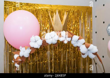 Zone photo pour une petite princesse: Une calèche et des ballons sur un fond doré brillant. Décor pour l'anniversaire d'un enfant Banque D'Images