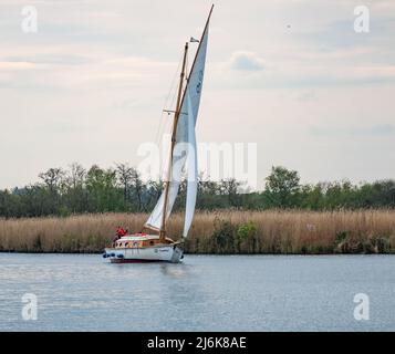 Voilier traditionnel en bois naviguant le long de la rivière Bure, Norfolk Broads Banque D'Images