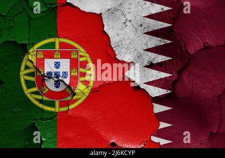 Drapeaux du Portugal et du Qatar peints sur un mur fissuré Banque D'Images