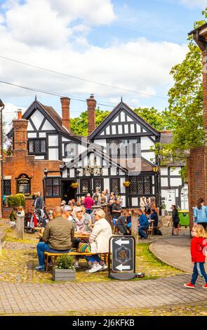 Les gens qui profitent du soleil printanier à l'extérieur du pub Lower Checkr, sur la place du marché du Cheshire, dans la ville de Sandbach, en Angleterre Banque D'Images