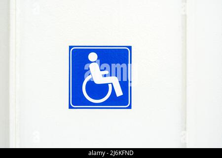 Autocollant carré simple de symbole de fauteuil roulant, étiquette sur un mur blanc, concept de problème d'accessibilité pour les personnes handicapées, panneau d'accès pour fauteuil roulant bleu clos Banque D'Images