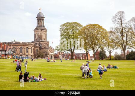 Les gens qui profitent du soleil de printemps en face de l'église St Chads Shrewsbury Shropshire situé au sommet de la zone de parc ouverte connue sous le nom de la carrière Banque D'Images