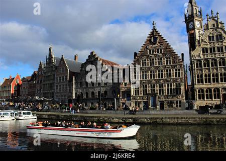 Une excursion touristique en bateau complète en passant par Graslei à Gand, en Belgique, dans un après-midi ensoleillé en hiver Banque D'Images