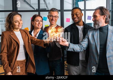 Travail d'équipe et remue-méninges avec des hommes d'affaires qui partagent une idée avec une lampe Banque D'Images