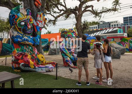 Une famille regarde la sculpture A Plastic Mum and Baby Monkeys d'Artur Bordalo (Bordalo II) à Wynwood Walls, Wynwood, Miami, Floride, USA Banque D'Images