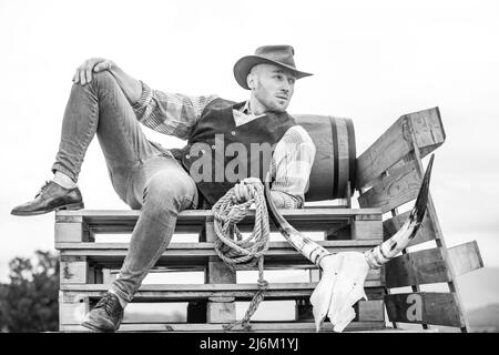 Cowboy portant un chapeau.La vie occidentale.Beau fermier de l'Ouest barbu.Portrait d'homme cow-boy ou fermier.Ouest.Mode rétro pour hommes, mode vintage, brutal Banque D'Images