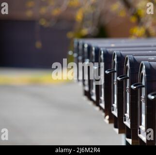 Alignement des boîtes aux lettres noires avec premier message indiquant que le courrier a été reçu pour le service de courrier américain profondeur de champ sélective espace ouvert pour le type profondeur de champ Banque D'Images