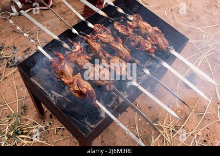 Préparation de la caille marinée sur la grille du gril. Photo de haute qualité Banque D'Images