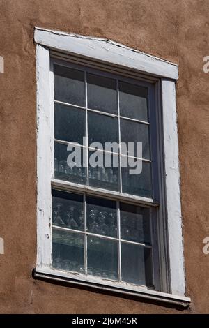 Verres dans la fenêtre avec bois blanc encadré dans le style adobe maison à Santa Fe Nouveau Mexique U.S.A. formes carrées ancien cadre de fenêtre architecture de style adobe Banque D'Images