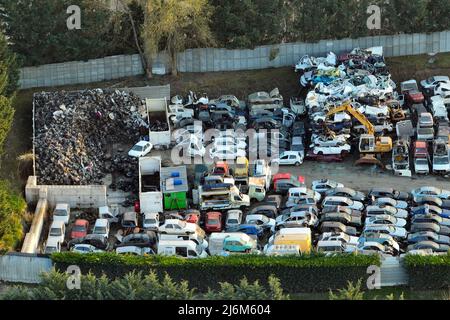 Vue aérienne du grand parking de junkyard avec des rangées de voitures brisées jetées. Recyclage des vieux véhicules Banque D'Images