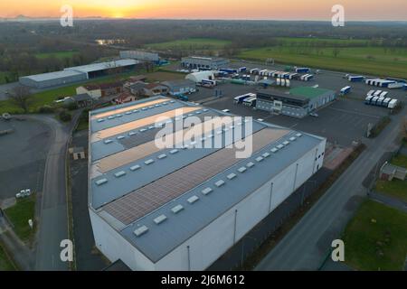 Vue aérienne des panneaux solaires photovoltaïques bleus montés sur le toit d'un bâtiment industriel pour produire de l'électricité écologique verte. Production de Banque D'Images