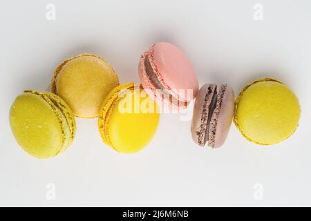 Macarons français multicolores en vol gelé sur fond blanc. Vacances, anniversaire, date romantique, nourriture sucrée, calories. Boutique, restaurant, café Banque D'Images