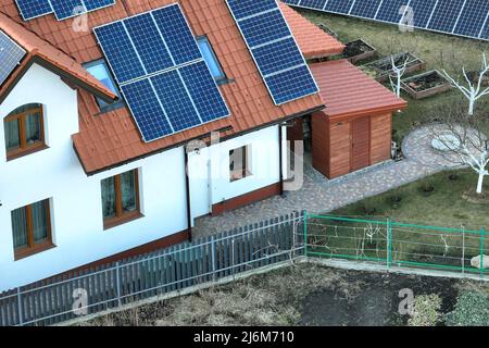 Toit de maison privé recouvert de panneaux photovoltaïques solaires pour la production d'énergie électrique écologique propre dans la zone urbaine rurale de banlieue. Concept de Banque D'Images