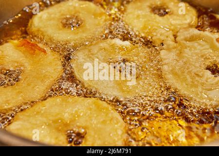 Cuisson de la crêpe aux pommes. Beignet de pomme dans de l'huile bouillante Banque D'Images